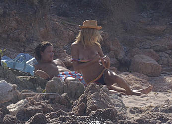 Supermodel Heidi Klum sunbathing topless at a beach in Italy