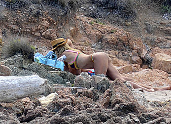 Supermodel Heidi Klum sunbathing topless at a beach in Italy