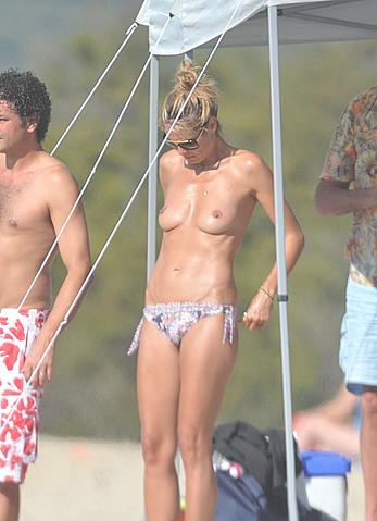 Heidi Klum sunbathing topless on a beach