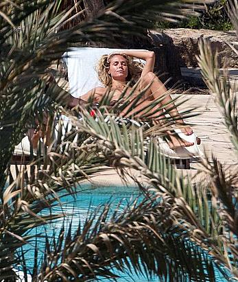 Heidi Klum sunbathing topless poolside