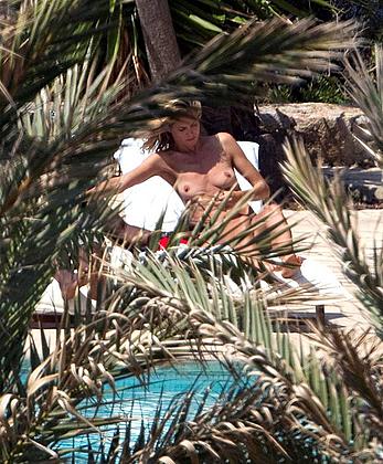 Heidi Klum sunbathing topless poolside