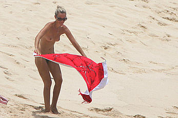 Laeticia Hallyday tanning topless on a beach