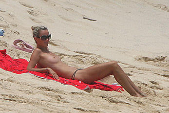 Laeticia Hallyday tanning topless on a beach