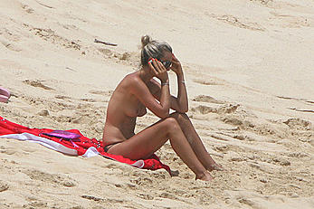 Laeticia Hallyday tanning topless on a beach