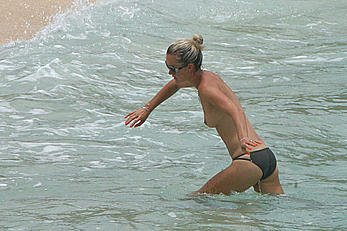 Laeticia Hallyday tanning topless on a beach