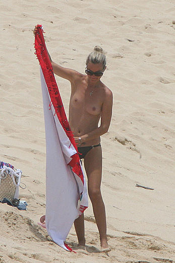 Laeticia Hallyday tanning topless on a beach