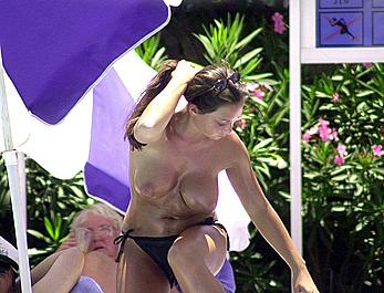 British Lucinda Rhodes-Flaherty sunbathing topless poolside