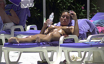 British Lucinda Rhodes-Flaherty sunbathing topless poolside