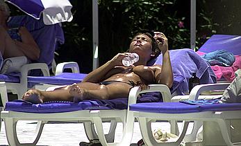 British Lucinda Rhodes-Flaherty sunbathing topless poolside