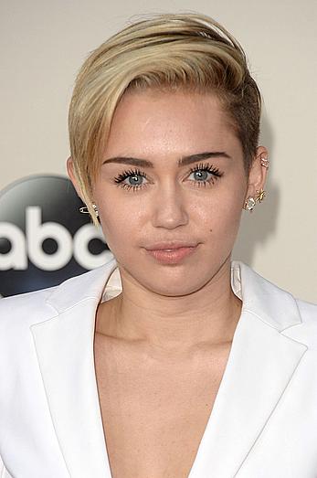 Miley Cyrus without bra under white jacket at 2013 American Music Awards