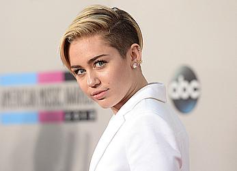 Miley Cyrus without bra under white jacket at 2013 American Music Awards