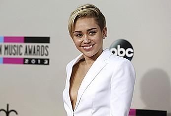 Miley Cyrus without bra under white jacket at 2013 American Music Awards