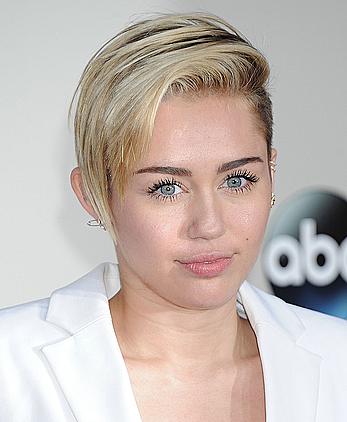 Miley Cyrus without bra under white jacket at 2013 American Music Awards