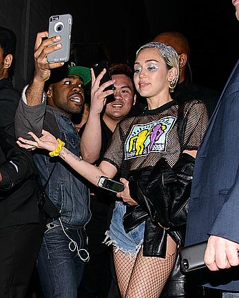 Miley Cyrus in a see through shirt and shorts