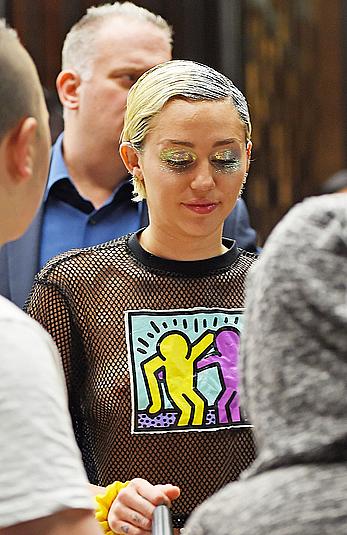 Miley Cyrus in a see through shirt and shorts