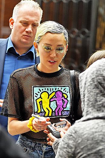 Miley Cyrus in a see through shirt and shorts