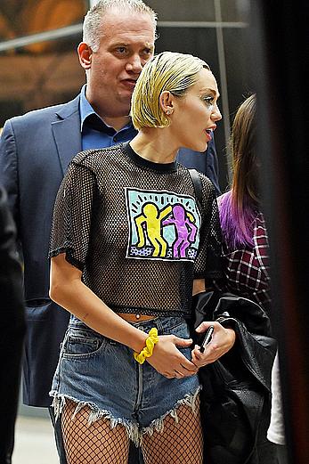 Miley Cyrus in a see through shirt and shorts