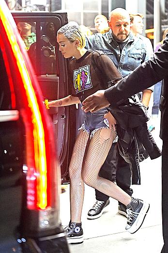 Miley Cyrus in a see through shirt and shorts