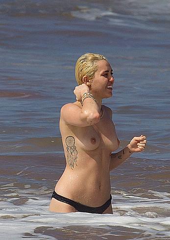 Miley Cyrus caught topless on a beach in Hawaii