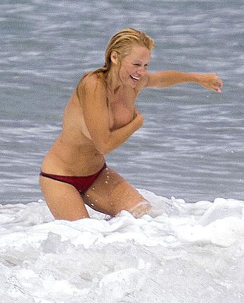 Busty Pamela Anderson goes topless on a beach in France