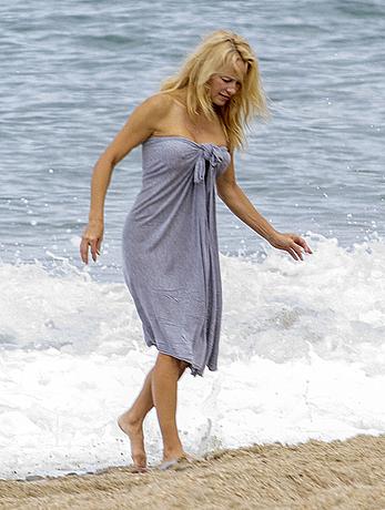 Busty Pamela Anderson goes topless on a beach in France