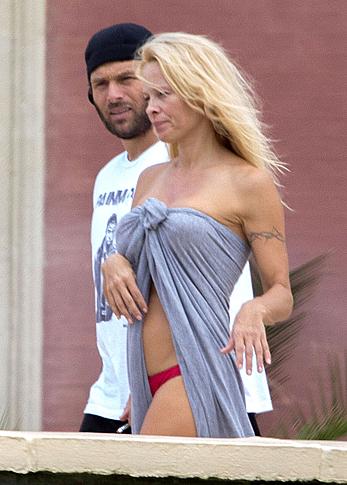 Busty Pamela Anderson goes topless on a beach in France