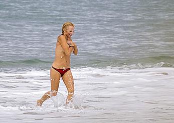 Busty Pamela Anderson goes topless on a beach in France