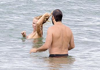 Busty Pamela Anderson goes topless on a beach in France