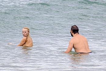 Busty Pamela Anderson goes topless on a beach in France