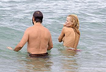 Busty Pamela Anderson goes topless on a beach in France