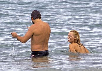 Busty Pamela Anderson goes topless on a beach in France