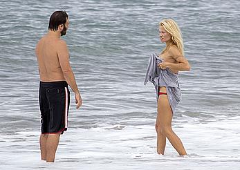 Busty Pamela Anderson goes topless on a beach in France