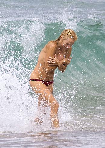 Busty Pamela Anderson goes topless on a beach in France