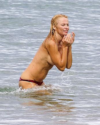 Busty Pamela Anderson goes topless on a beach in France