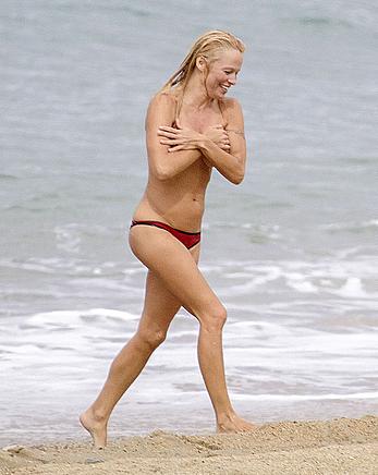 Busty Pamela Anderson goes topless on a beach in France