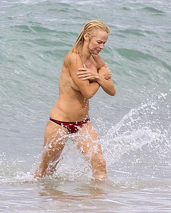 Busty Pamela Anderson goes topless on a beach in France