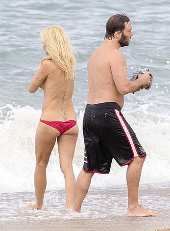 Busty Pamela Anderson goes topless on a beach in France