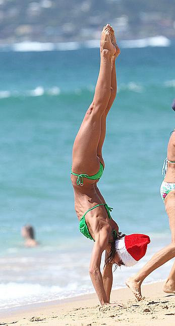 Sharni Vinson in green bikini aerobics on the beach in Sydney