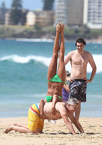 Sharni Vinson in green bikini aerobics on the beach in Sydney