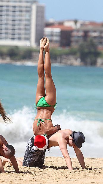 Sharni Vinson in green bikini aerobics on the beach in Sydney