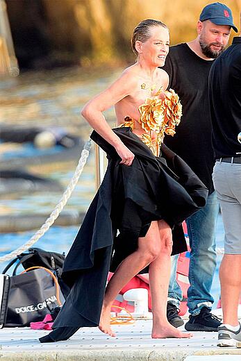 Sharon Stone wardrobe malfunction in black and gold flower top dress in southern France