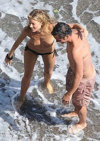 Sienna Miller caught topless on a beach