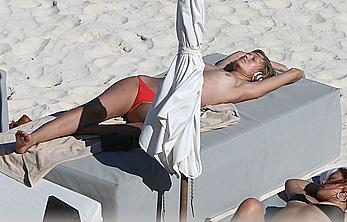 Toni Garrn sunbathing topless on the beach in Miami