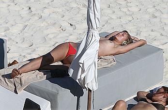 Toni Garrn sunbathing topless on the beach in Miami