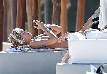 Toni Garrn sunbathing topless on the beach in Miami