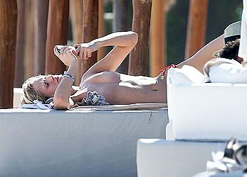 Toni Garrn sunbathing topless on the beach in Miami