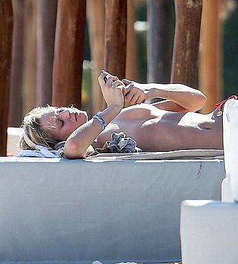 Toni Garrn sunbathing topless on the beach in Miami