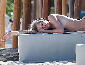 Toni Garrn sunbathing topless on the beach in Miami