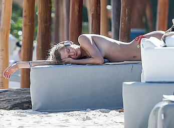 Toni Garrn sunbathing topless on the beach in Miami