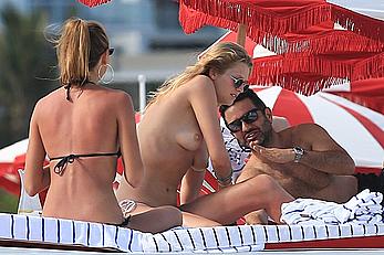 Toni Garrn topless on a beach with friends